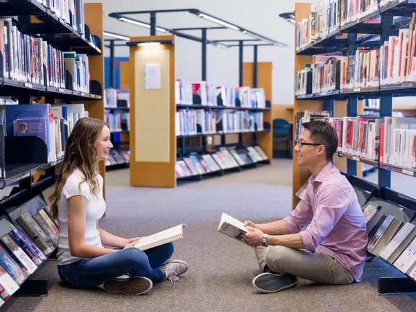 Dva mladí studenti v knihovně — Stock fotografie