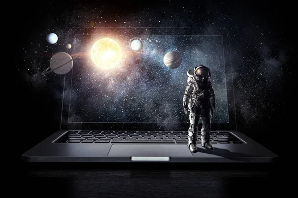 Space explorer and laptop. Mixed media — Stock Photo, Image