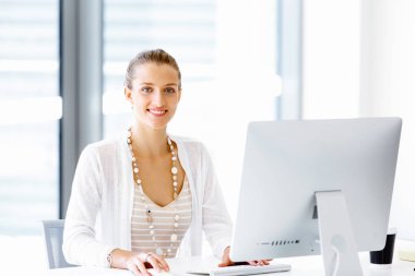 Çekici ofis çalışanı masada oturuyor.