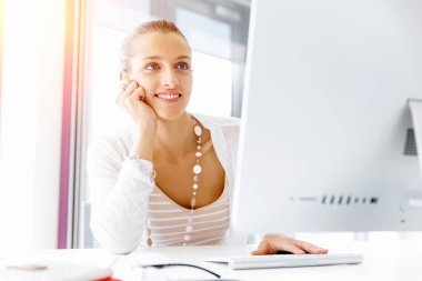 Çekici ofis çalışanı masada oturuyor.