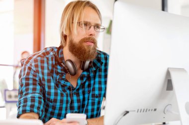 Genç adam ofiste çalışıyor.