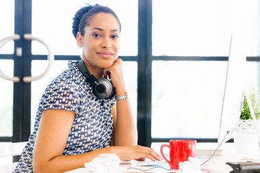 Afro-Amerikan ofis çalışanı iş içinde oturan gülümseyen portresi