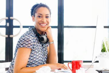 Afro-Amerikan ofis çalışanı iş içinde oturan gülümseyen portresi