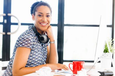 Afro-Amerikan ofis çalışanı iş içinde oturan gülümseyen portresi