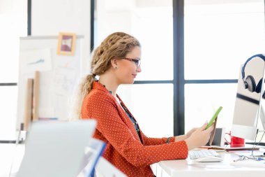 Ofiste bir fotoğraf çerçevesi tutan genç kadın