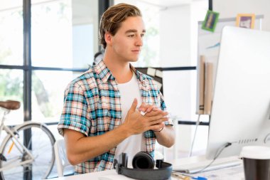 Genç adam ofiste çalışıyor.