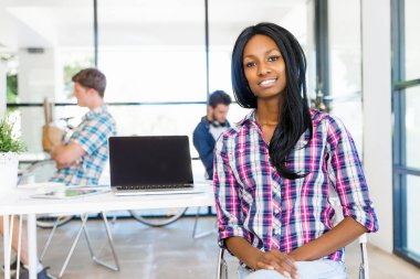 Afro-Amerikan ofis çalışanı iş içinde oturan gülümseyen portresi