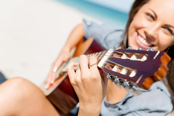 Piękna młoda kobieta gra na gitarze na plaży — Zdjęcie stockowe