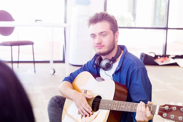 Jovem tocando guitarra no escritório — Fotografia de Stock