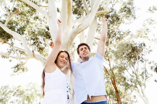 Young couple in the park celebrating — Stock Photo, Image