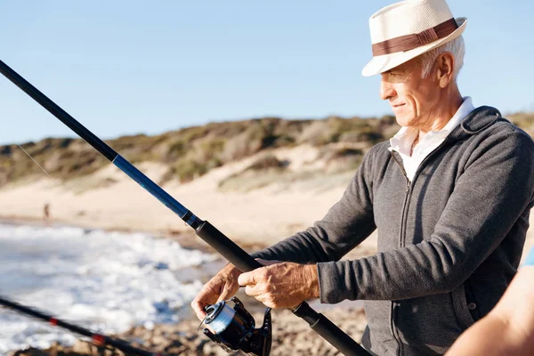 Homem sênior de pesca ao lado do mar — Fotografia de Stock