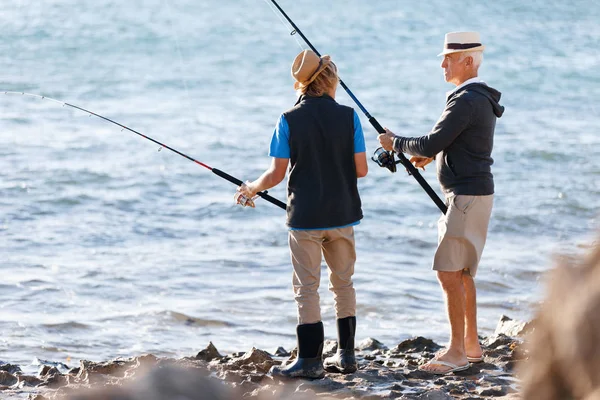 Uomo anziano pesca con suo nipote — Foto Stock