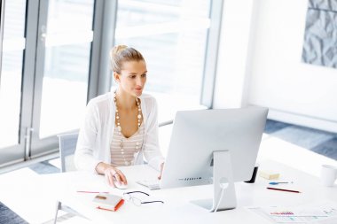 Çekici ofis çalışanı masada oturuyor.