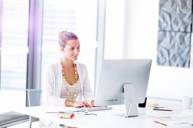 Çekici ofis çalışanı masada oturuyor.