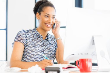 Afro-Amerikan ofis çalışanı iş içinde oturan gülümseyen portresi