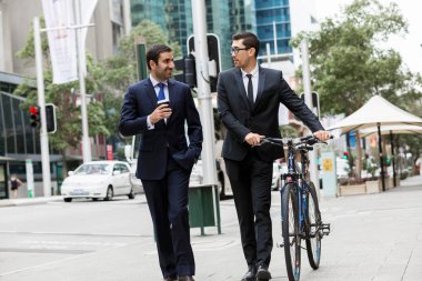 İki genç işadamları ile bir bisiklet şehir merkezinde