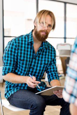 Genç adam ofiste çalışıyor.