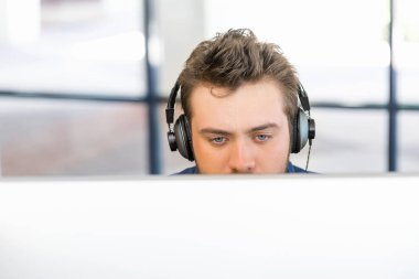 Genç adam ofiste çalışıyor.