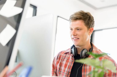 Genç adam ofiste çalışıyor.