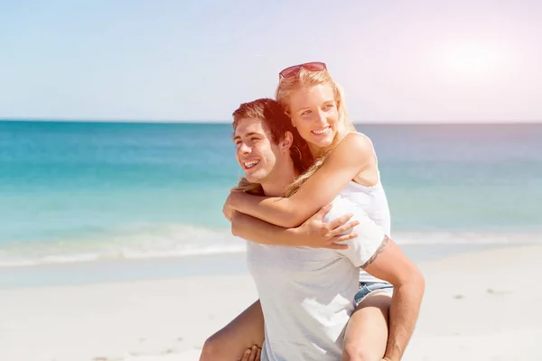 Portrait of man carrying girlfriend on his back — Stock Photo, Image