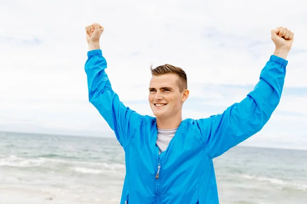 Young man in sport wear with outstretched arms — Stock Photo, Image