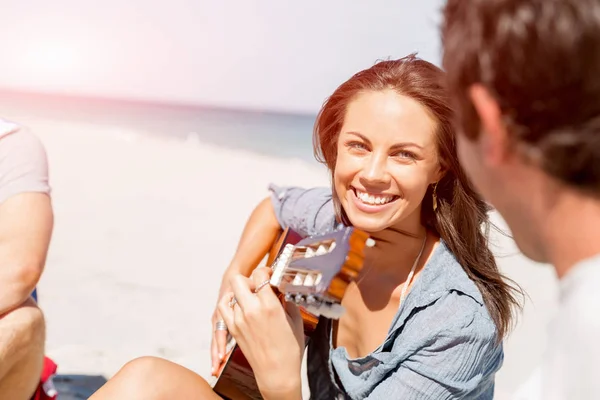 Güzel genç bir kadın sahilde gitar çalıyor. — Stok fotoğraf