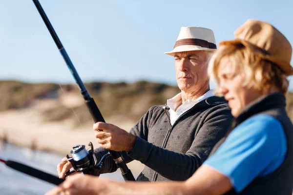 Hombre mayor pescando con su nieto — Foto de Stock