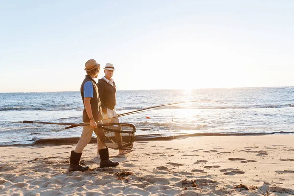 Hombre mayor pescando con su nieto — Foto de Stock