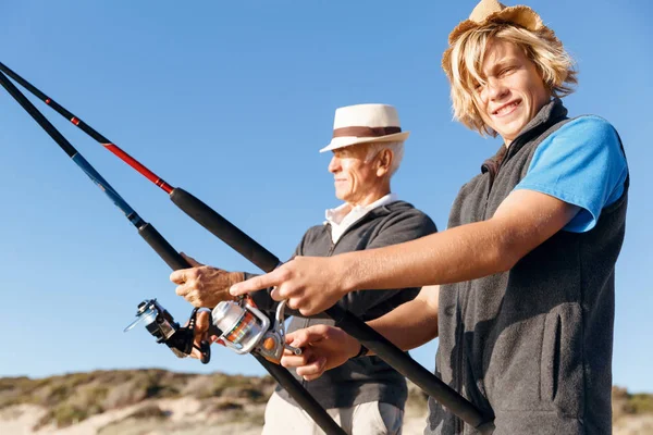 Hombre mayor pescando con su nieto —  Fotos de Stock