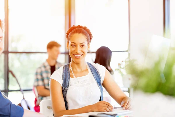 Portret van Afro-Amerikaanse kantoor werknemer zitten in offfice glimlachend — Stockfoto