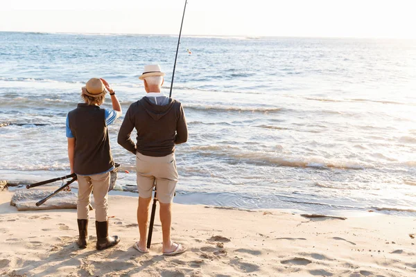 Uomo anziano pesca con suo nipote — Foto Stock