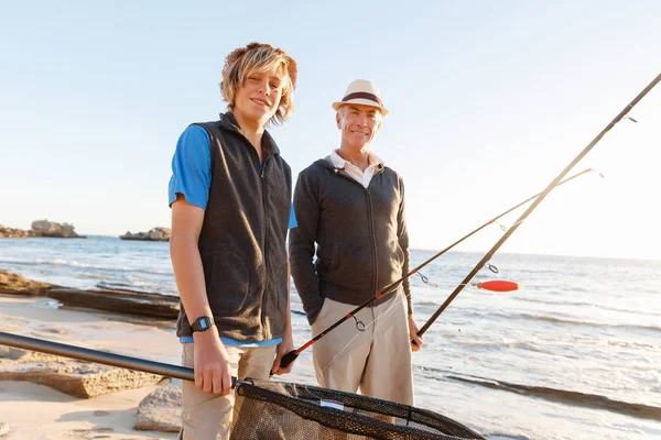 Hombre mayor pescando con su nieto — Foto de Stock