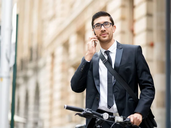 Homens de negócios jovens com uma bicicleta — Fotografia de Stock