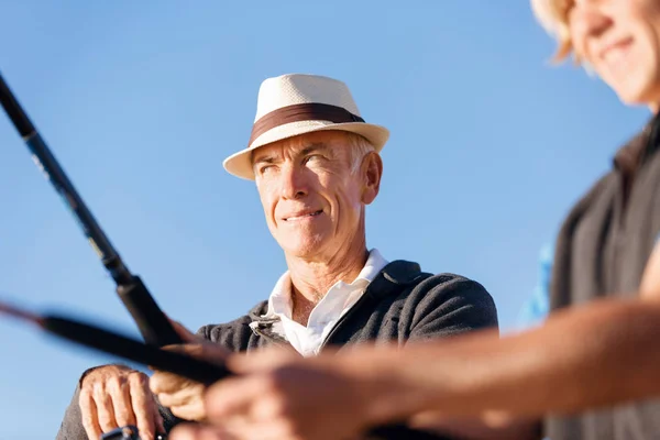 Uomo anziano pesca con suo nipote — Foto Stock