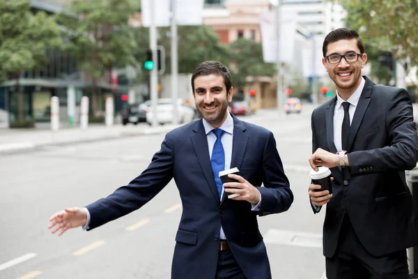 Dos jóvenes hombres de negocios pidiendo un taxi — Foto de Stock
