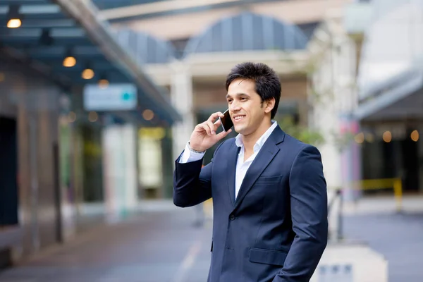 Портрет впевненого бізнесмена з мобільним телефоном на відкритому повітрі — стокове фото