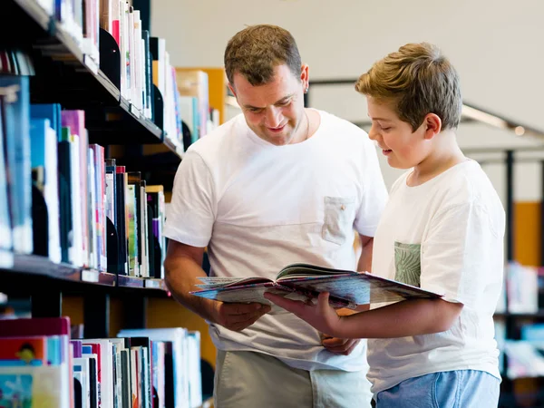 男孩和他父亲在图书馆 — 图库照片