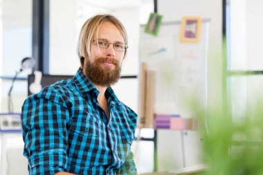 Genç adam ofiste çalışıyor.