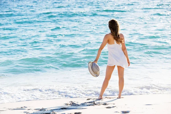 Mujer joven caminando por la playa — Foto de Stock