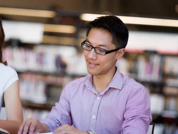 Happy manlig student håller böcker på biblioteket — Stockfoto