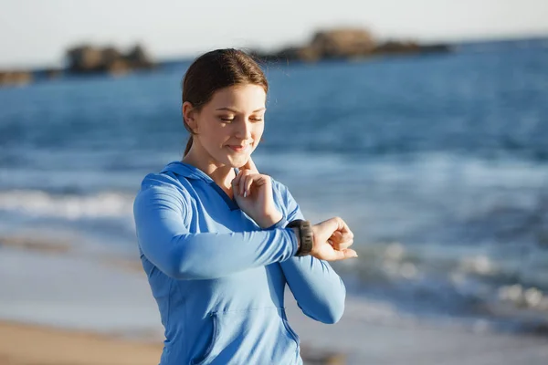 Loper vrouw met hartslagmeter uitgevoerd op strand — Stockfoto