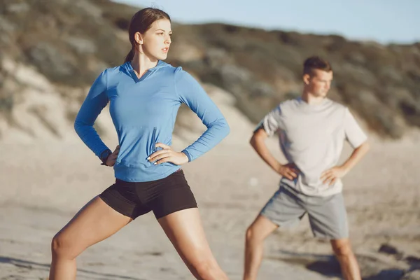 Jeune couple sur la plage d'entraînement ensemble — Photo