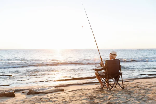 Senior mens vissen op zee zijkant — Stockfoto