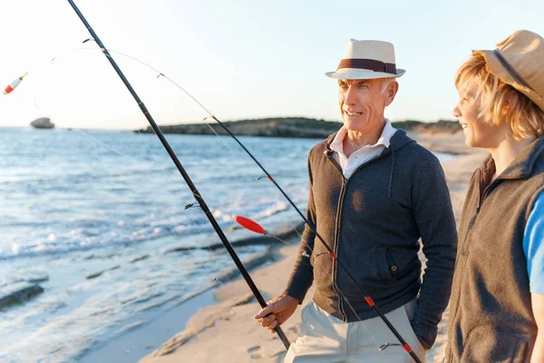 Hombre mayor pescando con su nieto — Foto de Stock