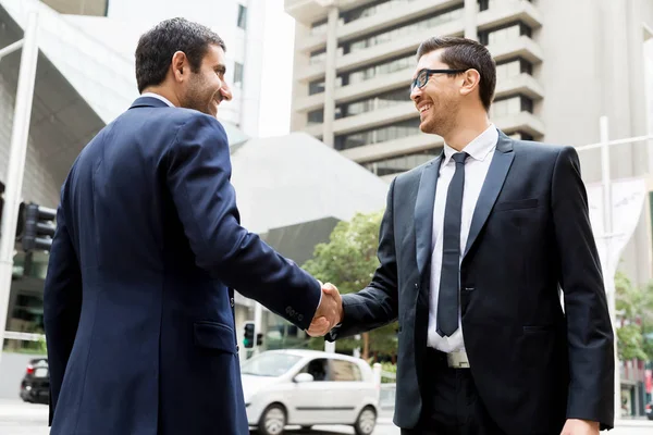 Dos hombres de negocios estrechando sus manos — Foto de Stock