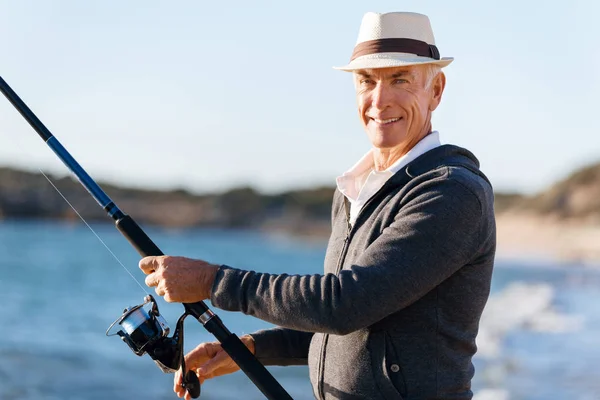 Senior mannen fiske till sjöss sida — Stockfoto