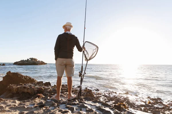 Senior mannen fiske till sjöss sida — Stockfoto