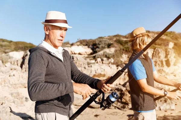 Uomo anziano pesca con suo nipote — Foto Stock