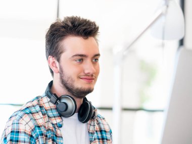 Genç adam ofiste çalışıyor.