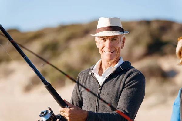 Homem sênior de pesca ao lado do mar — Fotografia de Stock